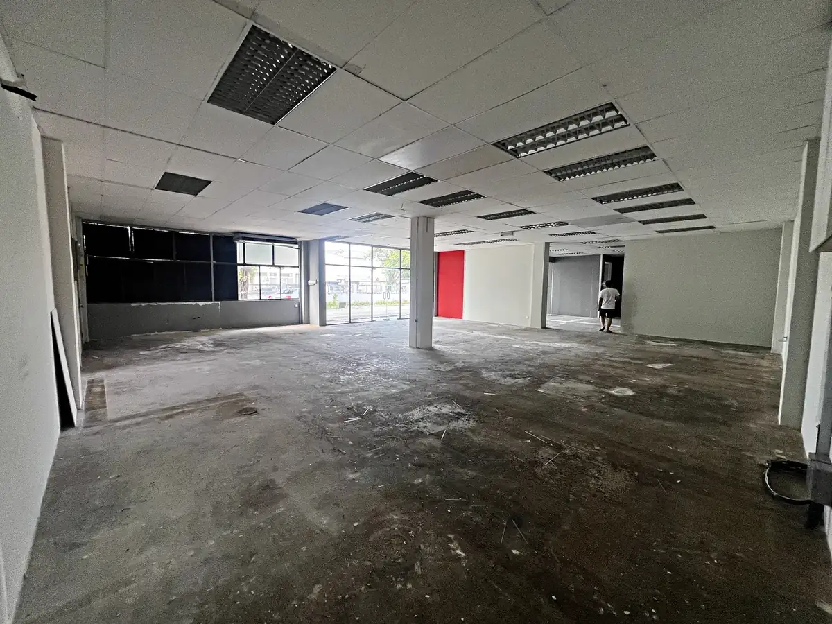 Stripped shop lot floor between tenants, showing where an unapproved extension or partition would be visible