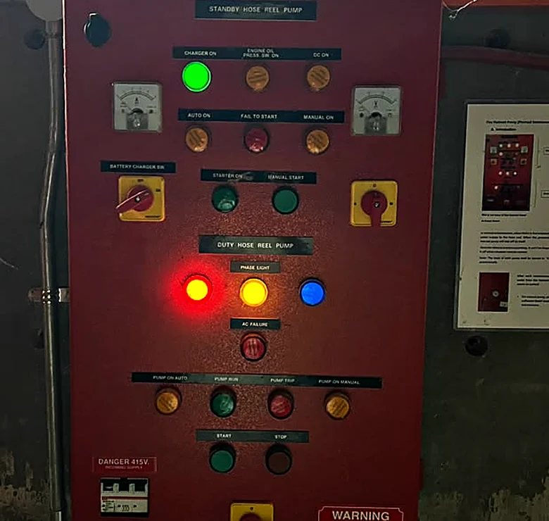 Red hose reel pump control panel with indicator lamps for charger, auto, pump run, phase fault and AC failure