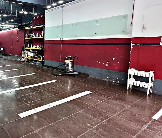 Interior of a ground floor shop unit with vehicle parking bays painted onto the ceramic tiled floor