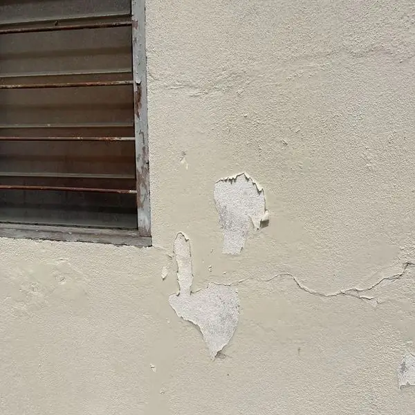 Steel louvre frame lifting away from the wall where trapped rust has expanded behind it